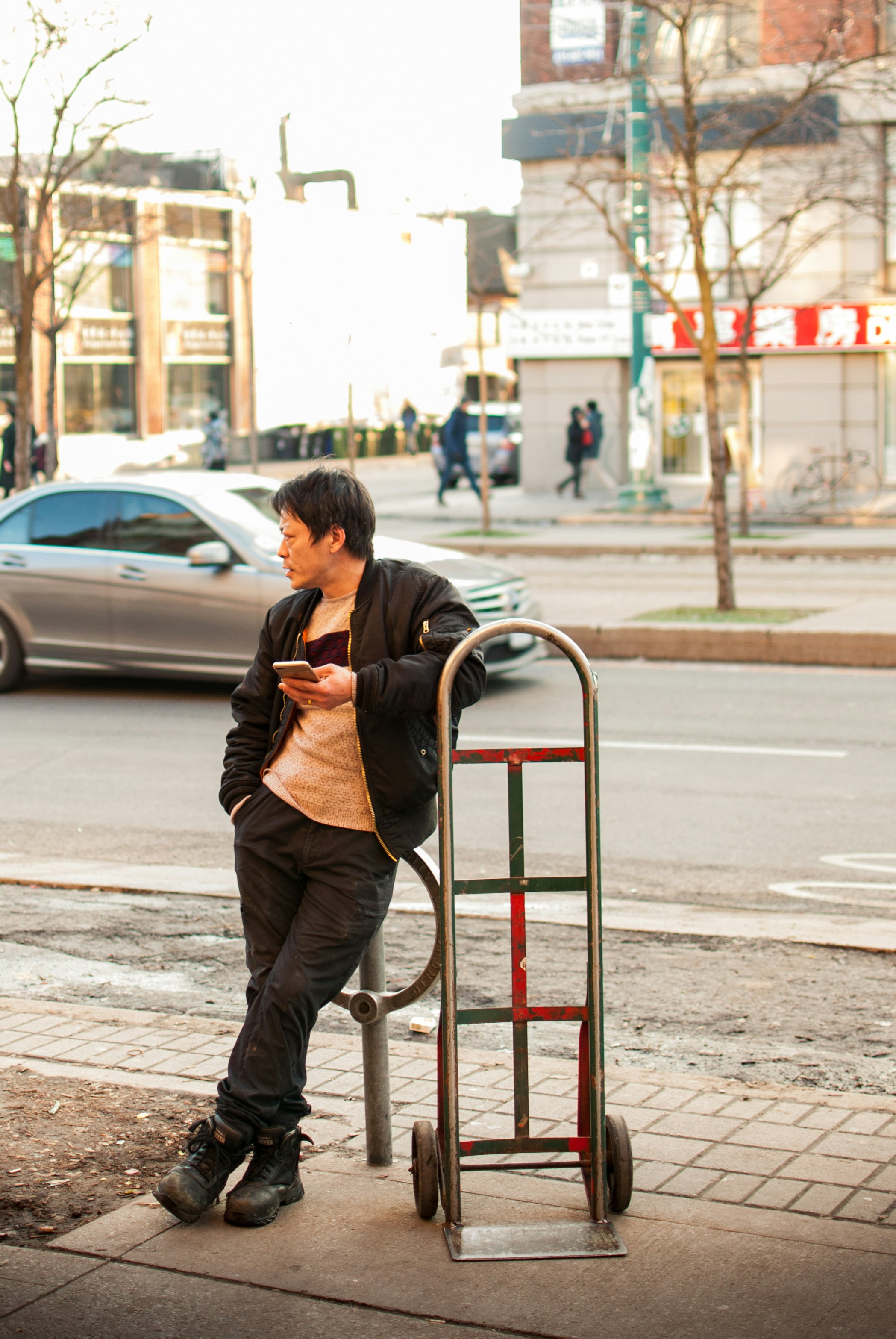 man standing beside hand truck